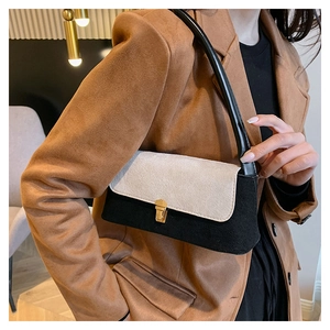 Detail view of the vintage contrast shoulder bag with a gold metal lock and matte texture