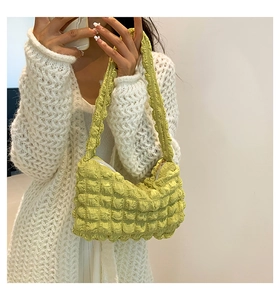 Close-up of soft yellow bubble textured cloud bag with a zipper and shoulder strap