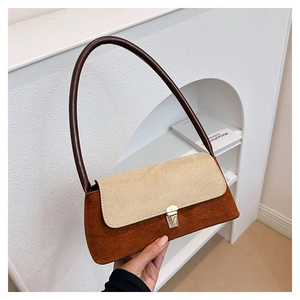 Detail showing the two-tone contrast design and golden metal lock on the suede bag