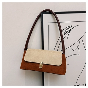 Close-up of retro color-block underarm bag with suede texture and metal clasp