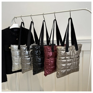Quilted puffer tote bags in metallic colors hanging on a minimalist white clothes rack