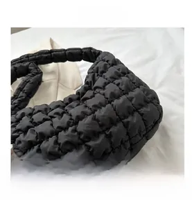 Detailed macro view of black quilted puff fabric and stylish cloud bag texture detail