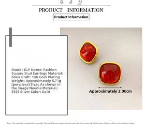 Detail view of square gold stud earrings with red stone inlay and size specifications