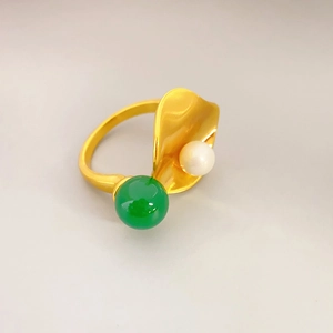 Golden lotus leaf ring with green chalcedony and pearl inlay on light gray background