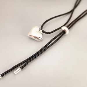 Polished silver heart pendant on a black twisted cord necklace with adjustable slider