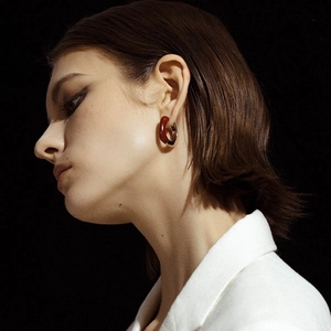 Modern enamel resin hoop earrings with silver metal and rich amber red contrast