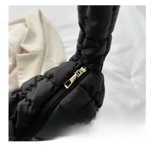 Detail of polished gold zipper hardware on premium black quilted nylon cloud bag