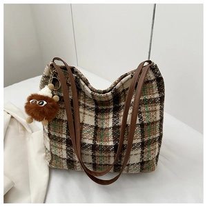 Nahaufnahme der Retro-Karo-Tote-Bag aus Tweed mit Lederriemen und Plüsch-Anhänger