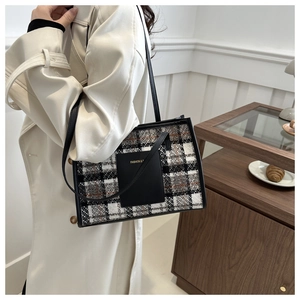 Primer plano del bolso tote vintage de tweed a cuadros con parche de cuero negro