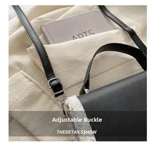Detail of adjustable metal buckle and plush trimming on black leather crossbody bag