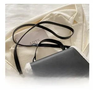 Detail showing the adjustable black leather strap and soft white faux fur trim on the bag