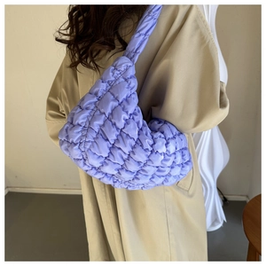 Close-up of fluffy lilac dumpling shoulder bag with padded quilted texture on model