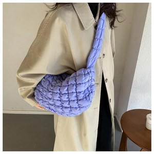 Close-up of lavender purple quilted cloud bag on shoulder with soft padded texture