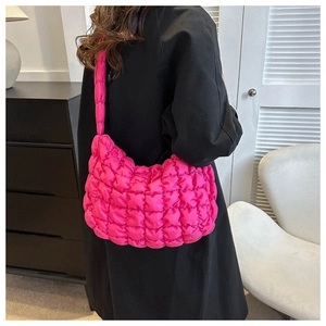 Detailed close-up of quilted nylon cloud bag in vibrant magenta with puffy texture