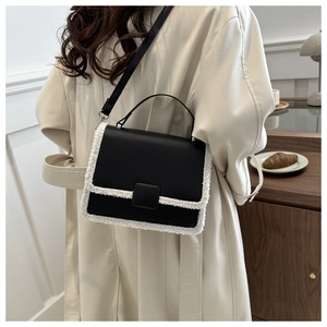 Ethnic style black crossbody bag with white faux fur trim and adjustable strap