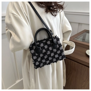 Detail of checkered tweed handbag with fringe edges and premium leather handles