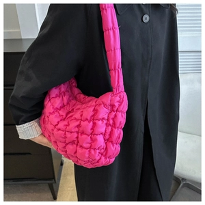 Detail of rose pink quilted cloud bag with puffy bubble texture on female model side view