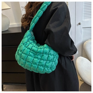 Detail of lime green quilted nylon puffer bag with textured bubble fabric and wide strap