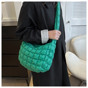 Detailed view of bright green quilted nylon cloud bag showing texture and size on shoulder