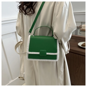 Green leather crossbody bag with white faux shearling trim shown on model