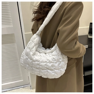 Rear view of a model wearing a white quilted puff shoulder bag with a stylish pleated texture