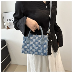 Vintage checkered denim tote bag with frayed edges and crossbody strap shown on model