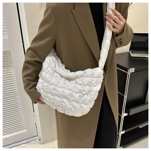 Detail of white quilted nylon cloud bag with lightweight pleated texture and wide strap