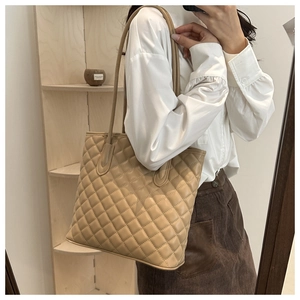 Detail shot of beige quilted tote bag with diamond stitching on high-quality leather