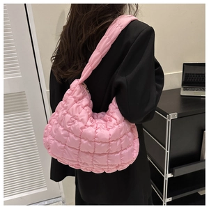 Detailed view of pink quilted nylon shoulder bag with soft cloud-like puff texture