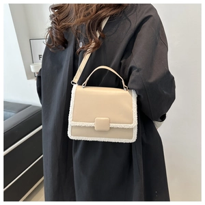Detail of beige shoulder bag with faux fur trim and sleek square closure buckle
