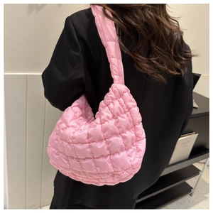 Detail of pink quilted puffer shoulder bag showing soft padded texture and crossbody style