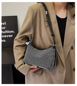 Détail du sac Hobo noir avec strass argentés et bandoulière en cuir nouée tendance