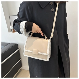 Chic beige crossbody bag with faux fur trim shown on a model wearing a black coat
