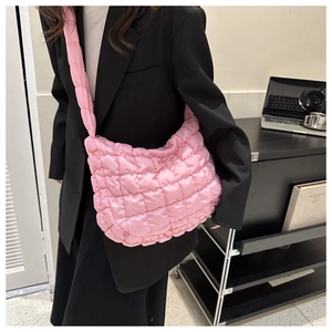 Detail of pink quilted puffy cloud bag with shoulder strap for a chic urban look