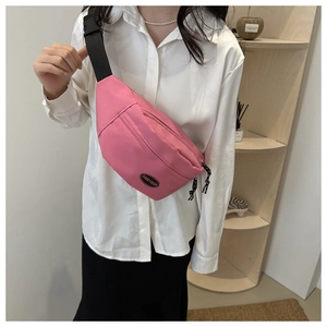 Detail of bright pink nylon fanny pack with adjustable black strap and woven zipper pull