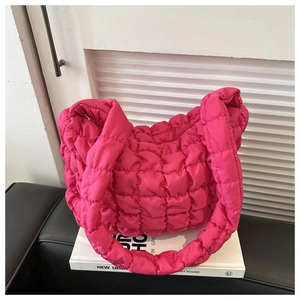 Close-up of bright pink quilted puffer bag with 3D bubble texture and soft nylon fabric