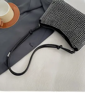 Détail du sac à bandoulière en strass argentés avec poignée en PU souple sur blazer gris