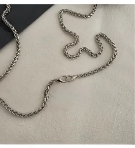Detail of silver alloy chain strap with lobster clasps and woven metal texture
