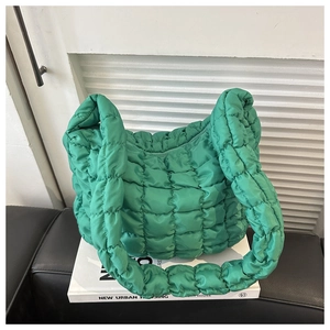 Close-up of green quilted bubble nylon shoulder bag featuring puffy square stitch texture