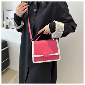 Detail of rose red crossbody bag with white faux fur trim and adjustable strap