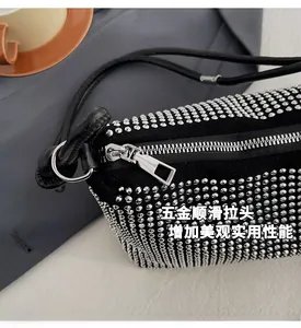 Détail de la fermeture éclair argentée sur un sac à main noir orné de strass brillants