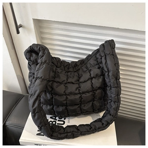 Detailed view of black quilted nylon puffer bag with soft texture and cloud-like padding