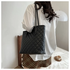 Detail of black quilted leather tote bag showing fine stitching and large capacity