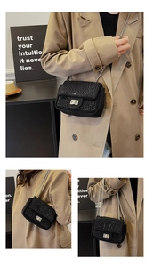 Detailed view of black rhinestone mini crossbody bag with silver rotating lock and chain