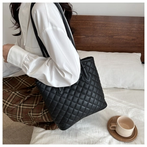 Detailed view of black quilted faux leather bucket bag with elegant diamond stitching