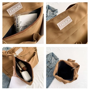 Detalle del bolso tote de lona marrón con múltiples bolsillos y pequeña bolsa interior