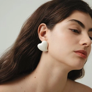 Élégantes boucles d'oreilles cœur en émail blanc argent 925 portées par un mannequin