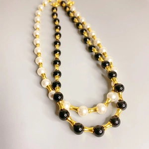Collier à maillons bambou avec perles d'agate noire et perles blanches dorées