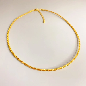 Detailed macro view of the twisted rope chain texture and golden lobster clasp closure