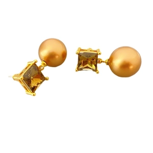 French style gold earrings featuring amber crystal and golden pearls on white background